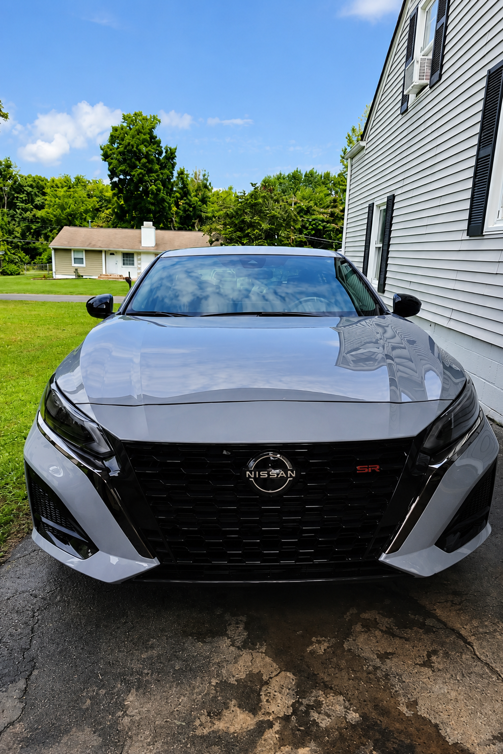 Silver Nissan Altima SR front view freshly detailed in a driveway
