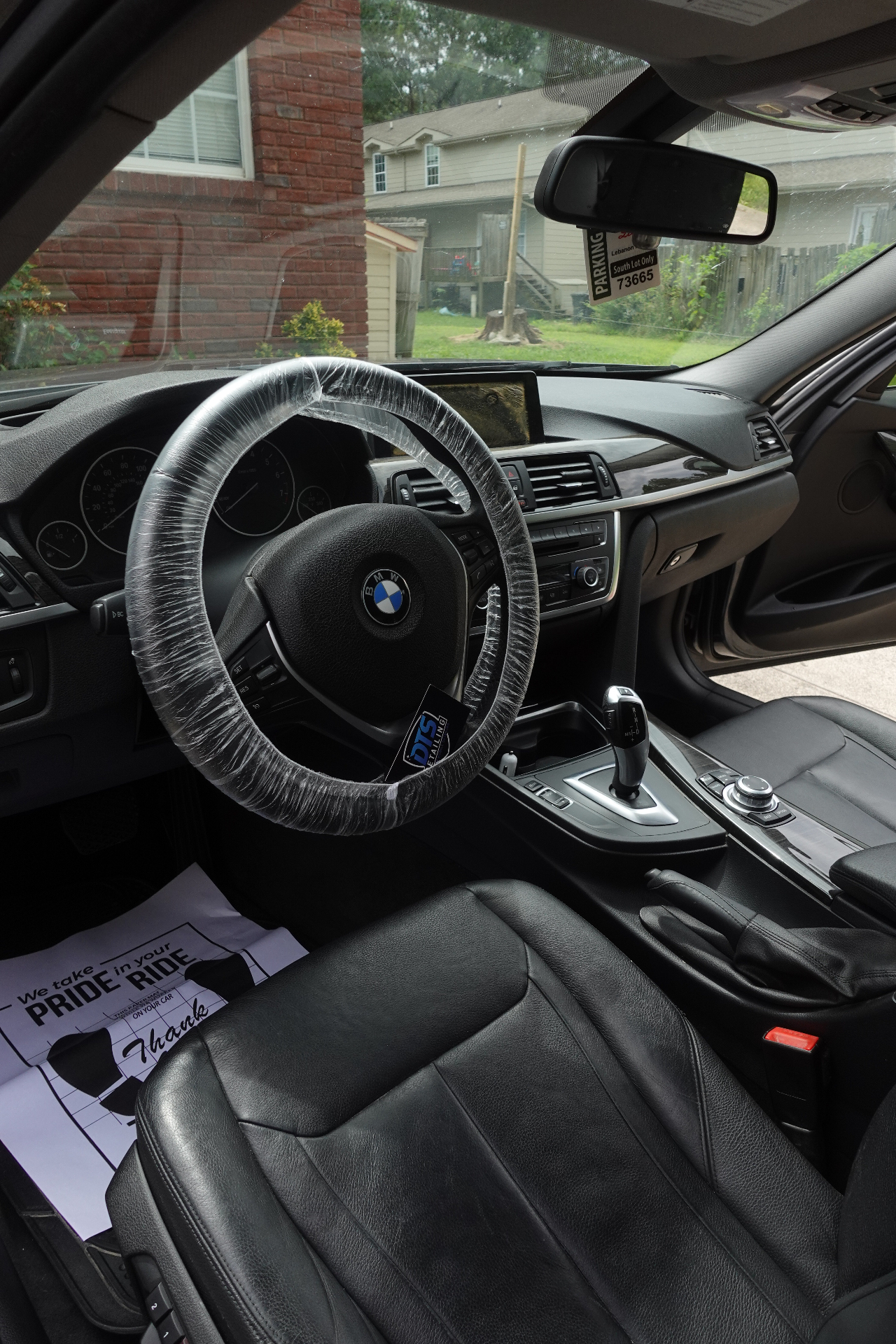 BMW front cabin with clean black leather seats, detailed dash and console after a full interior detail