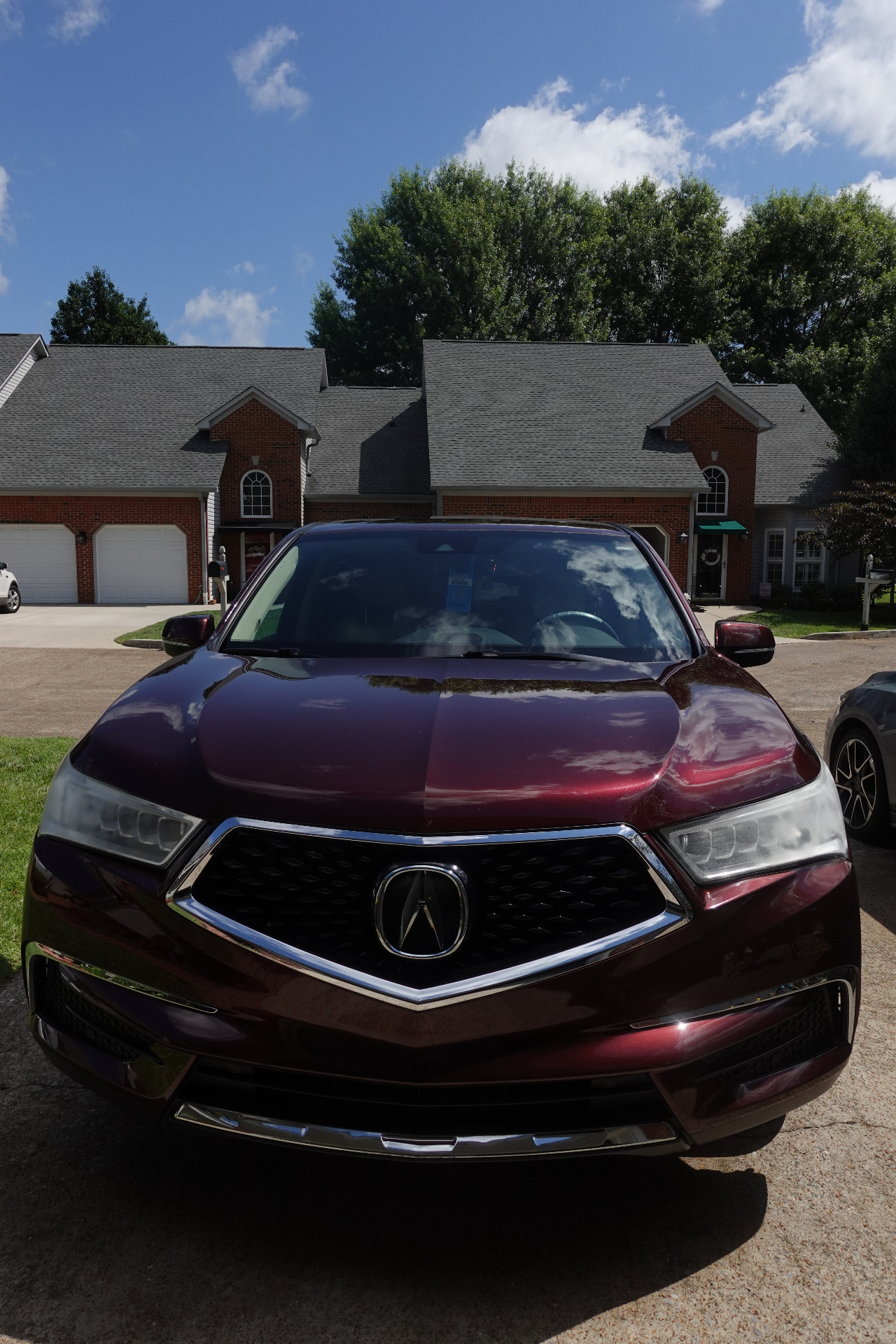 Acura MDX front exterior freshly detailed with glossy maroon paint