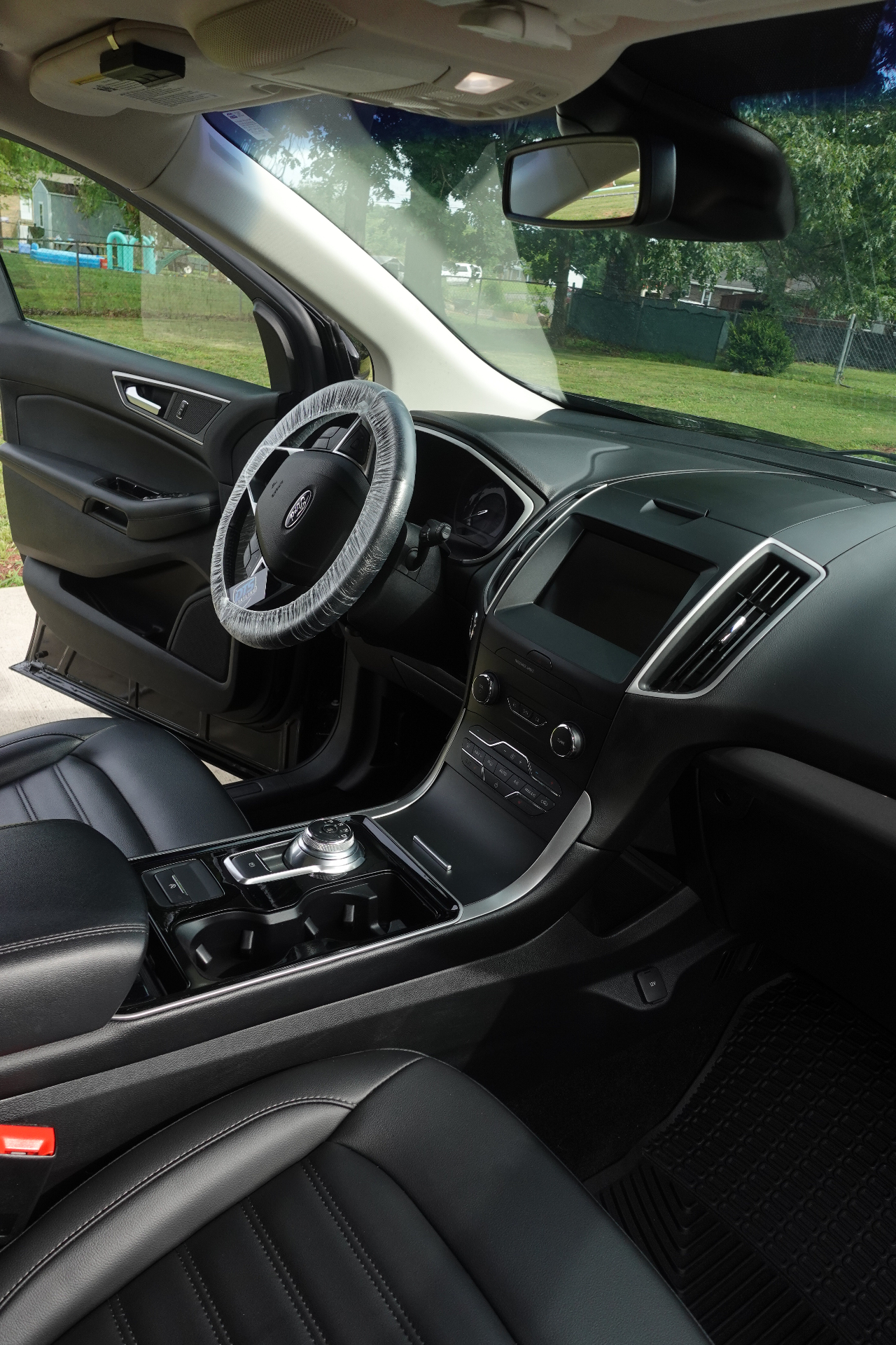 Wide view of the Ford Edge front cabin with clean leather seats and detailed dash after an interior detail
