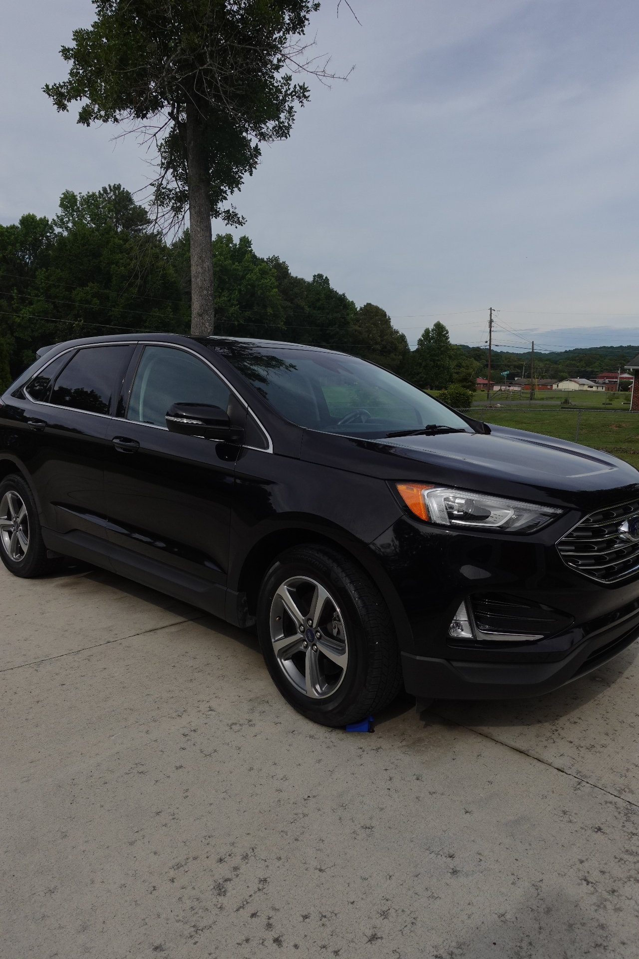 Side profile of a black Ford Edge SUV with a glossy paint finish after a full exterior detail