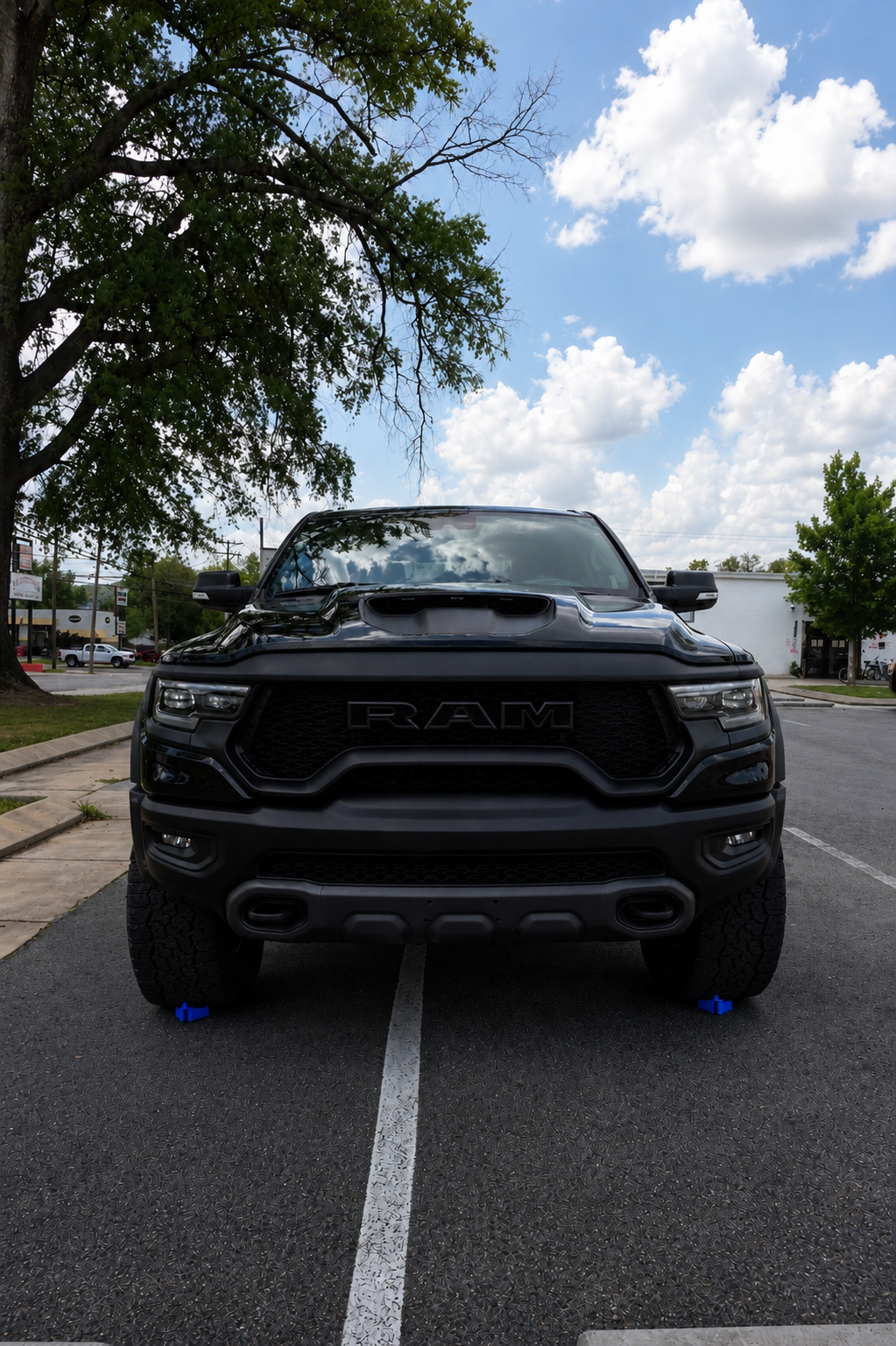 Blacked-out Ram TRX front view on jack pads after a full exterior detail