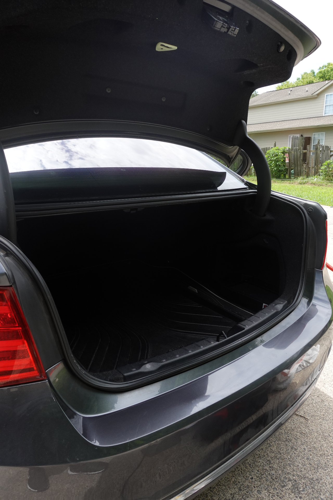 BMW trunk opened wide showing a freshly vacuumed cargo area and clean trunk trim after an interior detail