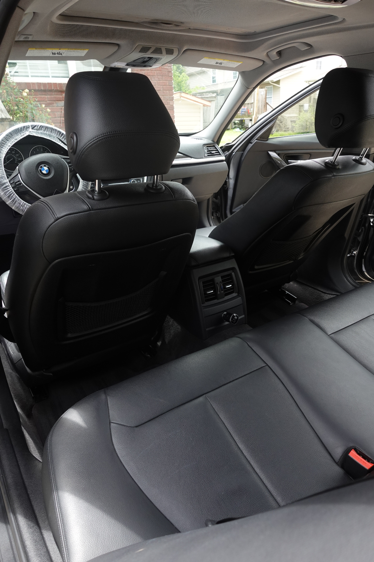 BMW rear seating area with clean black leather, spotless rear console vents, and detailed interior surfaces