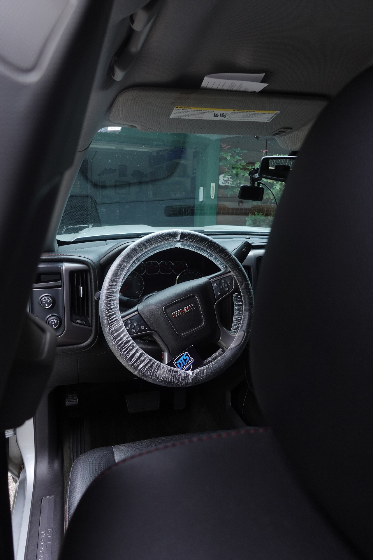 GMC Sierra interior with DTS Detailing protective steering wheel cover during a mobile detail